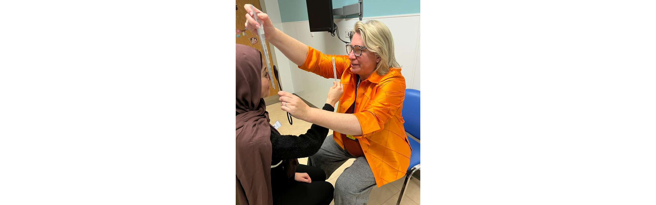 Image shows the Master examining the alignment of a patient's eye as an Orthoptist at St Thomas' Hospital.