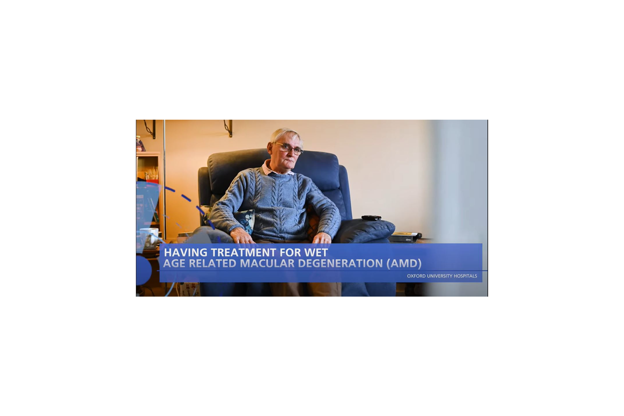 Elderly man seated in his living room. Text on the screen reads 'Having treatment for Age Related Macular Degeneration (AMD)'. 
