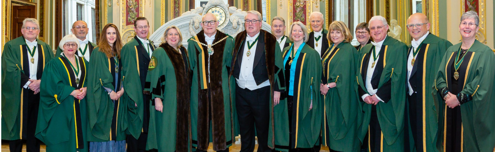 Image shows members of our governing Court (7 women, 10 men) wearing ceremonial gowns, ribbons and badges of office.  They are all smiling broadly.