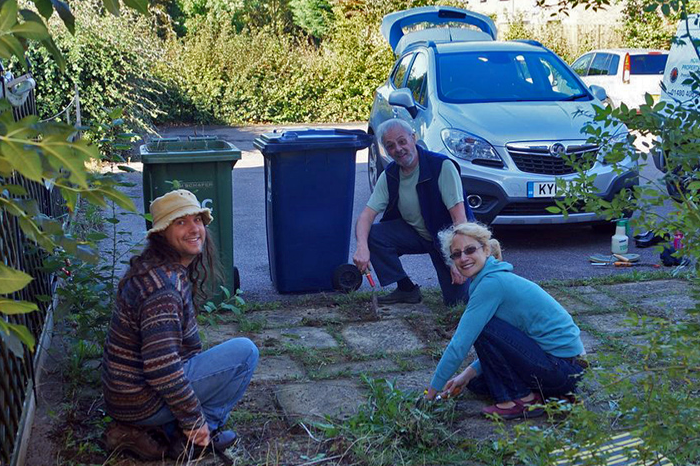 A group of people helping one another with tasks in the garden.