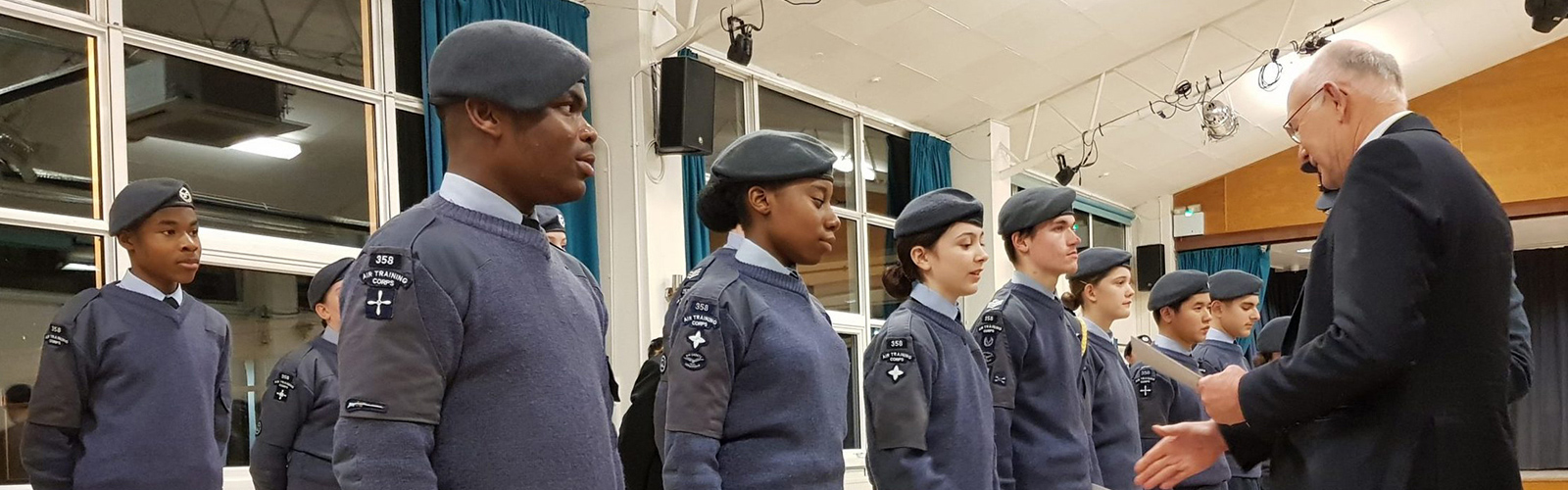 Image shows young RAF air cadets (ages 11-14) receiving awards from a senior Company official