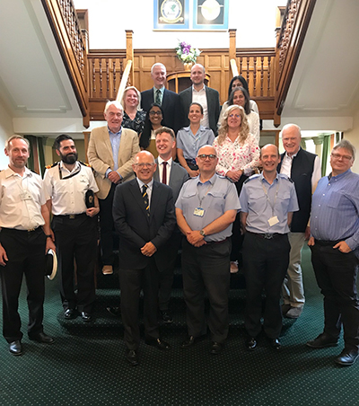 Spectacle Makers standing on a staircase at RAF Henlow with serving aviation health experts.